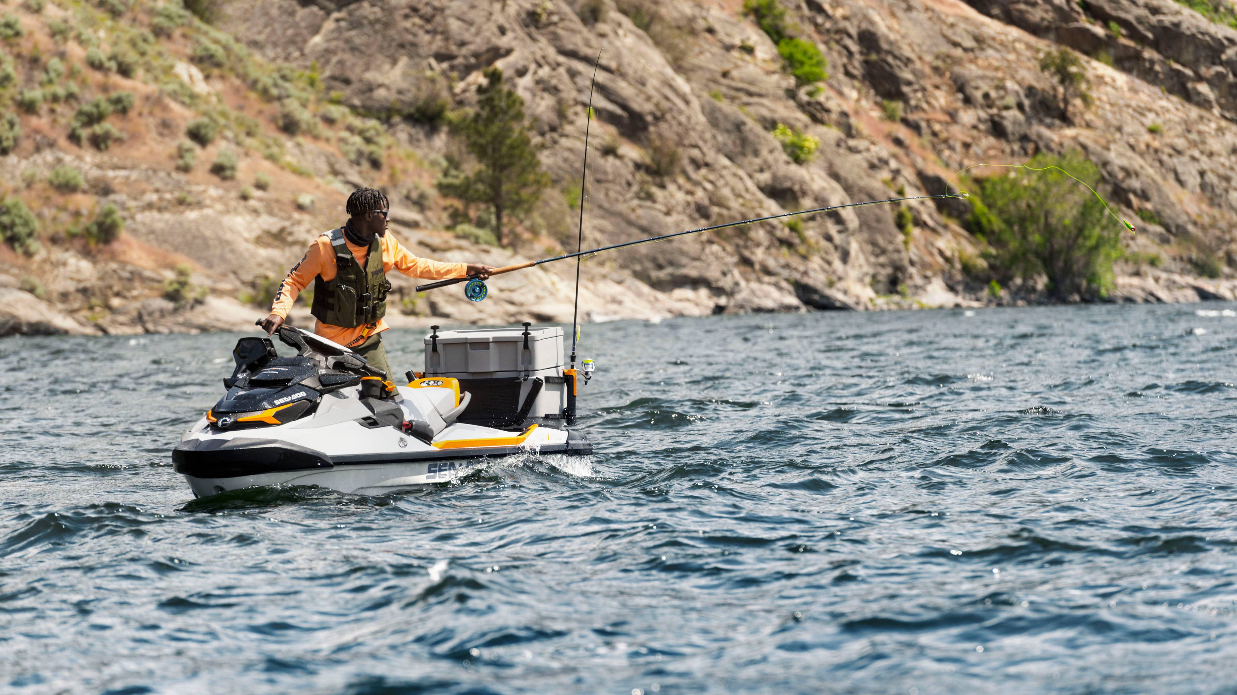 Emmanuel Williams fiskar samtidigt som han håller i styret på en Sea-Doo FishPro Trophy