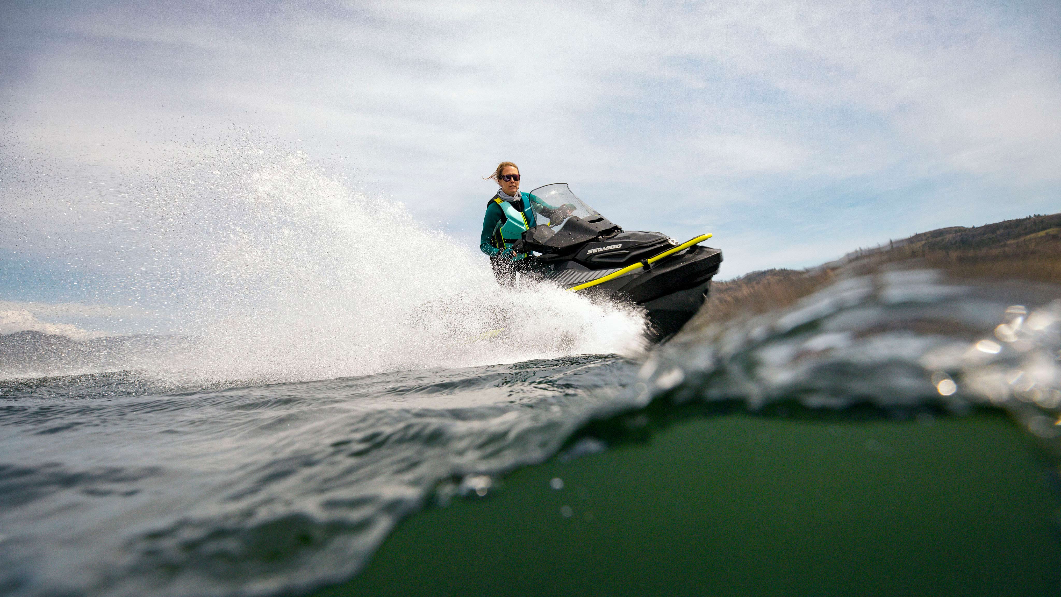 一个女子正驾驶着一辆装有前保险杠的 Sea-Doo Explorer Pro 170 摩托艇